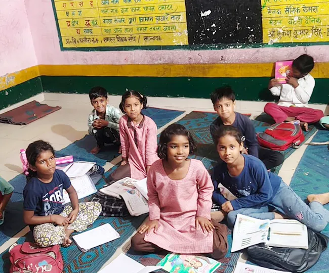 मंडी धनौरा के कन्या प्राथमिक विद्यालय में फर्नीचर होने के बावजूद जमीन पर बैठकर पढ़ाई करते विद्यार्थी। जागरण